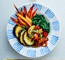 Aubergine goulash with spinach and sweet potato fries in bowl