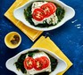 Baked cod with spinach topped with tomatoes in dish