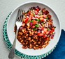 Black-eyed bean mole topped with tomato salsa in bowl with fork