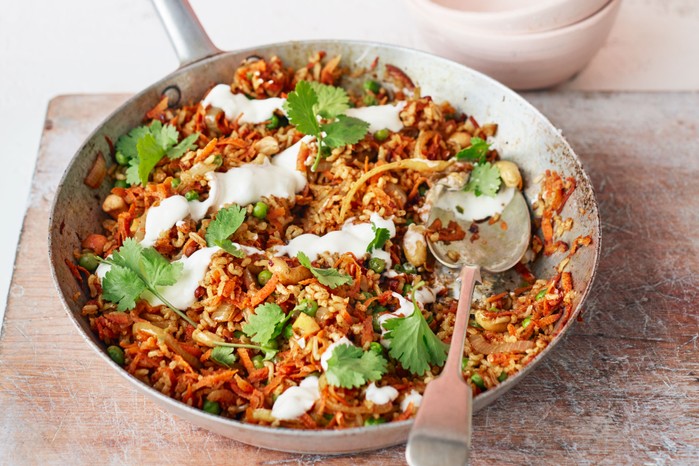 Carrot biriyani in a pot with a spoon