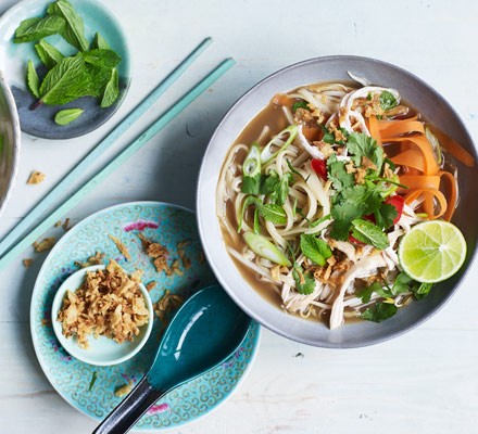 Noodle soup in bowl with chopsticks and side plate