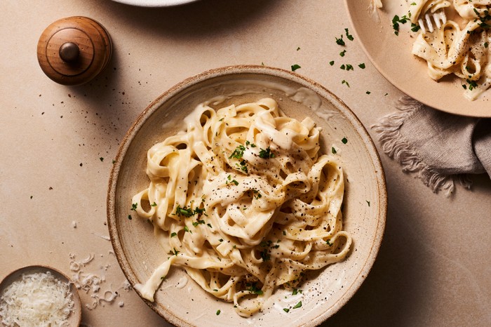 Three plates of creamy garlic pasta