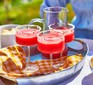 Four glasses of frozen watermelon margarita on a platter