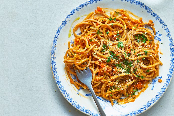 Plate of spaghetti with jackfruit bolognese topped with vegan parmesan