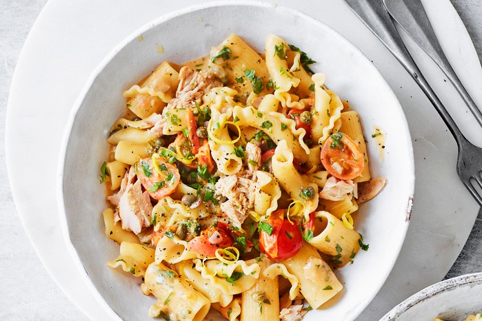 Rigattoni with tuna, tomatoes and capers in a white bowl