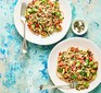 Two plates serving linguine with avocado, tomato & lime