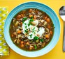 Mushroom and potato soup with carrots in bowl with spoon