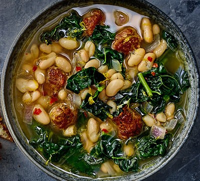 Cavolo nero, meatball & cannellini soup on grey background