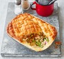 Pea & ham pot pie served in a pie dish with cutlery alongside