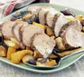 Sliced pork tenderloin fillets on a traybake of vegetables