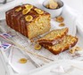 Sliced banana bread topped with drizzle and banana chips on a serving plate