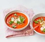 Two bowls of red pepper & tomato soup with ricotta in two bowls