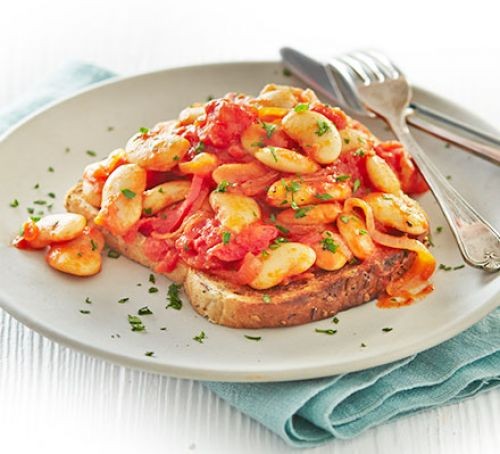 Smokey butter beans in tomato sauce on toast, on a plate