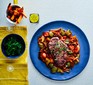 Steak with goulash on plate with sweet potato chips and spinach in bowl