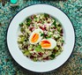 Tabbouleh salad in bowl topped with hard boiled egg