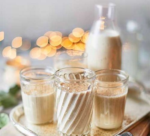 eggnog in glass jug and glasses