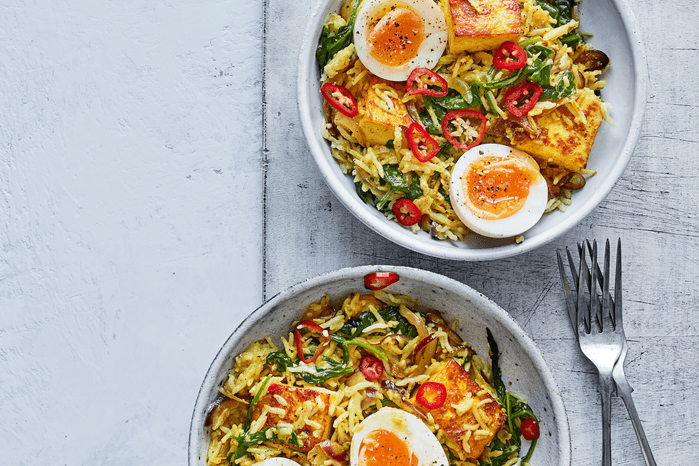 Saag paneer rice in bowls with boiled eggs on top