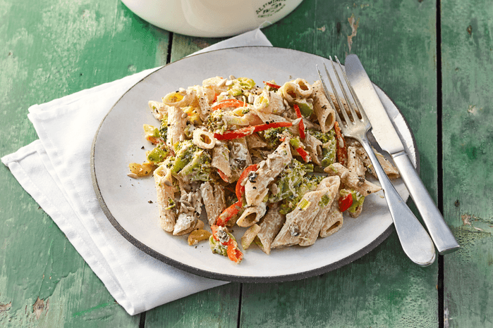 Creamy lemon and anchovy pasta on a plate with a knife and fork